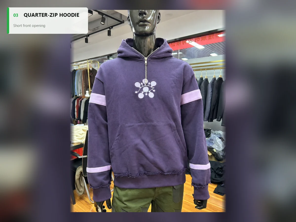Purple quarter-zip hoodie with a short chest zipper, sleeve bands and embroidered motif